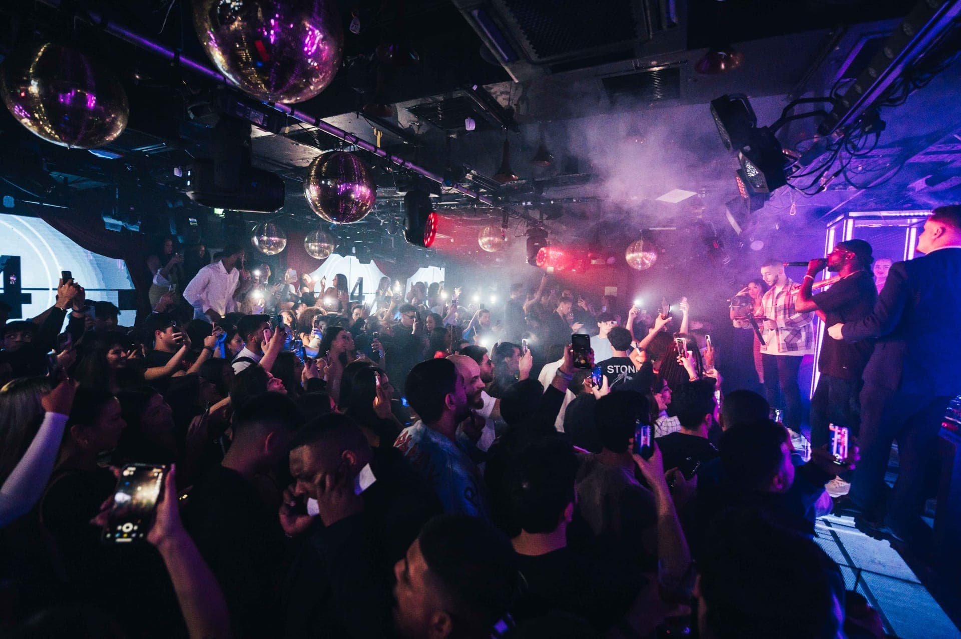 Private event setup inside a luxury London nightclub with bottle service and atmospheric lighting